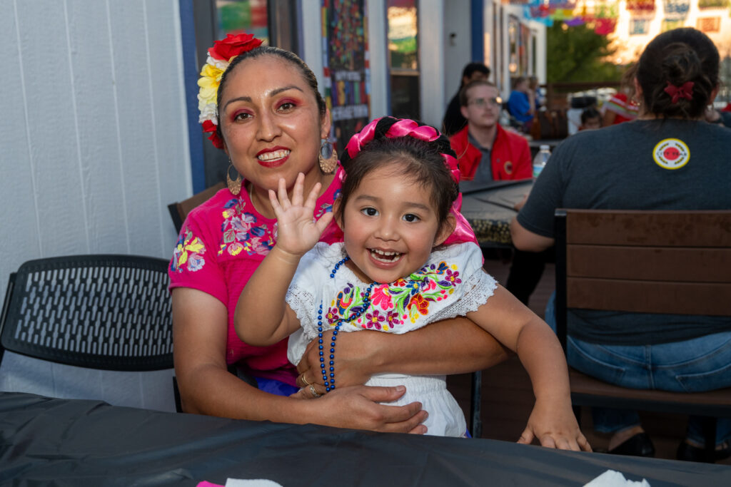 woman and child in brightly dressed clothes celebrating